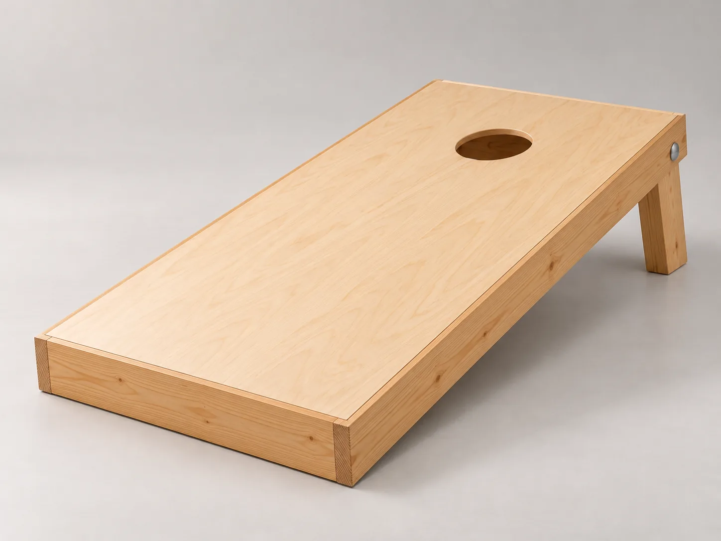 Regulation cornhole board in birch plywood on a 2x4 frame, with a 6 inch hole near the raised end and a folding leg
